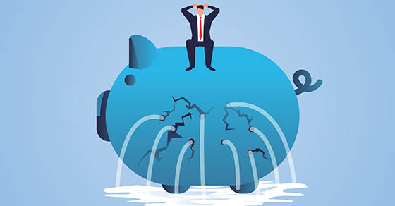 Businessman sitting on a leaky piggy bank
